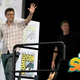 two white males wave at the audience